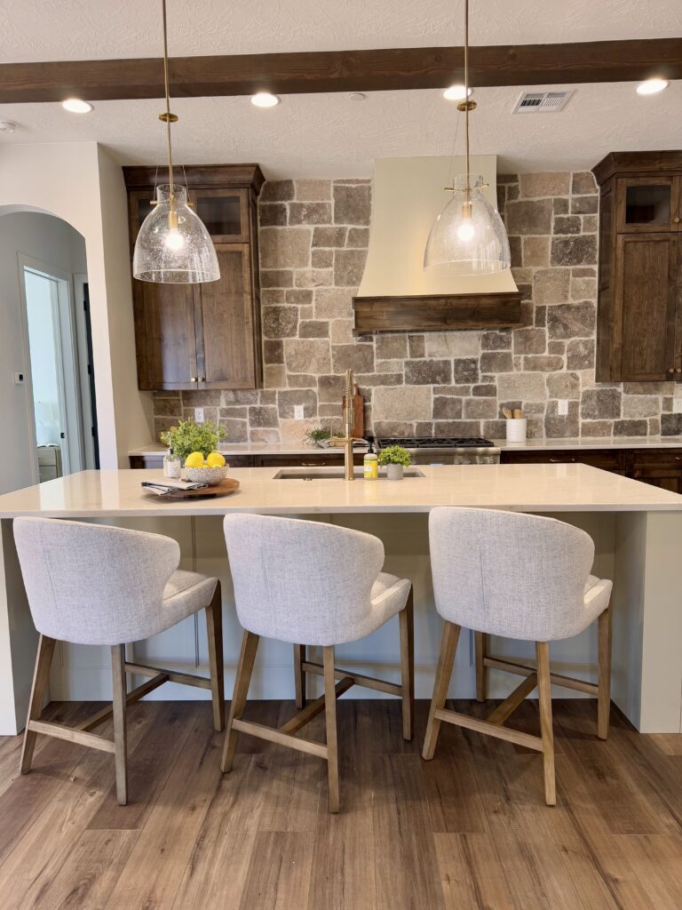 Professional home staging in Southern Utah featuring a kitchen island with bar seating, pendant lighting, and warm wood cabinetry